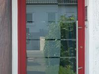 Haustür mit rotem Rahmen und großer Scheibe