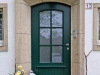 Holz-Haustür in dunkelgrün mit Sprossenfenster