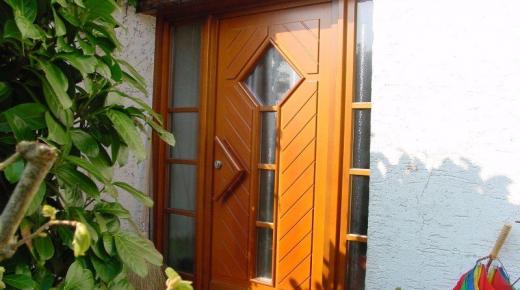 Holz-Haustür in braun mit zwei Seitenteilen und Fischgrät-Verbretterung