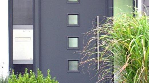PaX Haustür in grau mit zwei Seitenteilen und integriertem Briefkasten