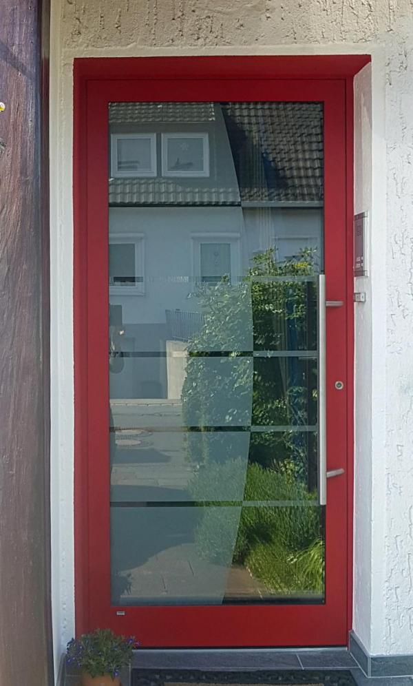 Haustür mit rotem Rahmen und großer Scheibe