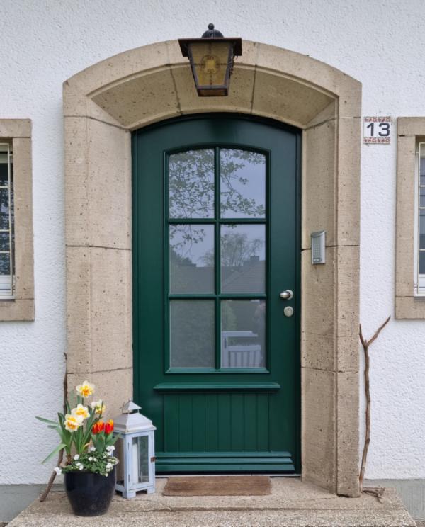Holz-Haustür in dunkelgrün mit Sprossenfenster