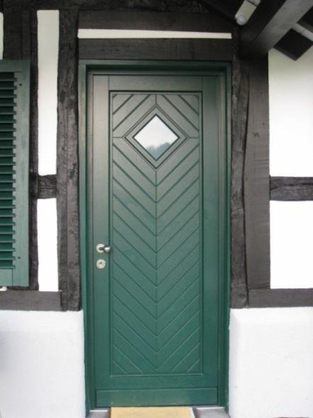 Holz-Haustür in grün mit Fischgrät-Verbretterung 