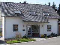 Einfamilienhaus mit Holz-Fenstern in grau