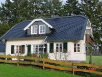 Einfamilienhaus mit Sprossenfenstern in weiß mit grauen Fensterläden