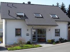 Einfamilienhaus mit Holz-Fenstern in grau