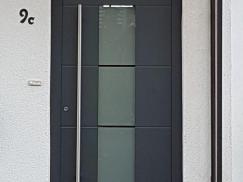 Haustür dunkelgrau mit Milchglas-Einsatz und Stangengriff