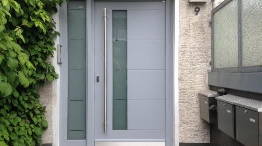 Haustür in hellgrau mit Seitenteil und Stangengriff
