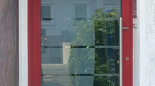 Haustür mit rotem Rahmen und großer Scheibe
