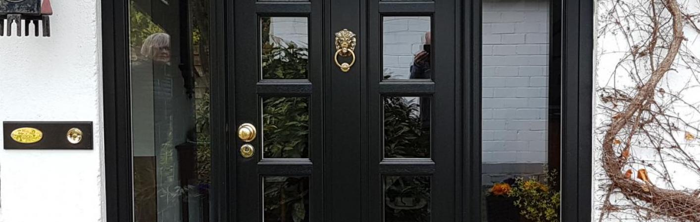 Holz-Haustür in schwarz mit Seitenteilen und Türklopfer